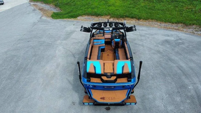 Slide: The Image of A 2027 Axis A245 boat with blue and brown accents, parked on an asphalt lot. - 3