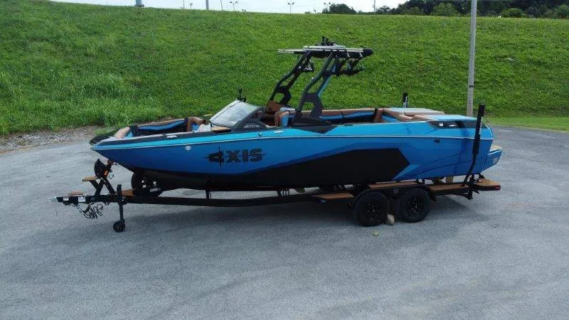 Slide: The Image of A blue Axis A245 boat from 2027 is on a trailer in a parking area. - 6