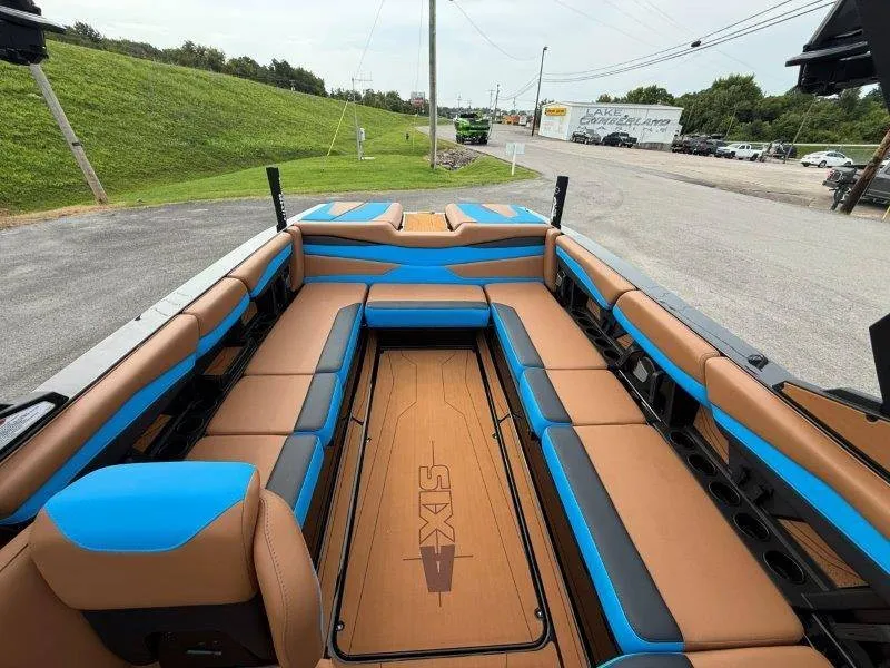 Slide: The Image of The image shows the interior of a 2027 Axis A245 boat with brown and blue seating. - 30