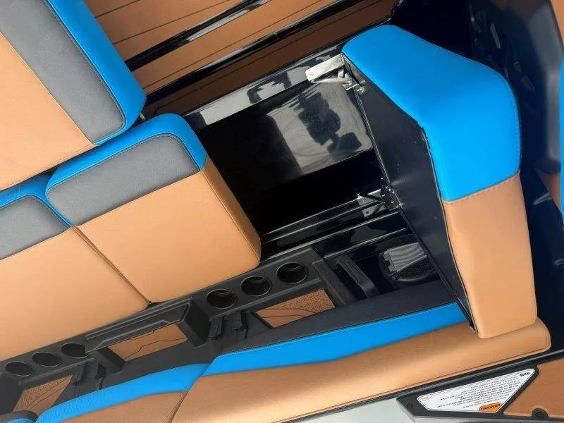 Slide: The Image of The interior of the 2027 Axis A245 features brown and blue upholstery with cup holders. - 36