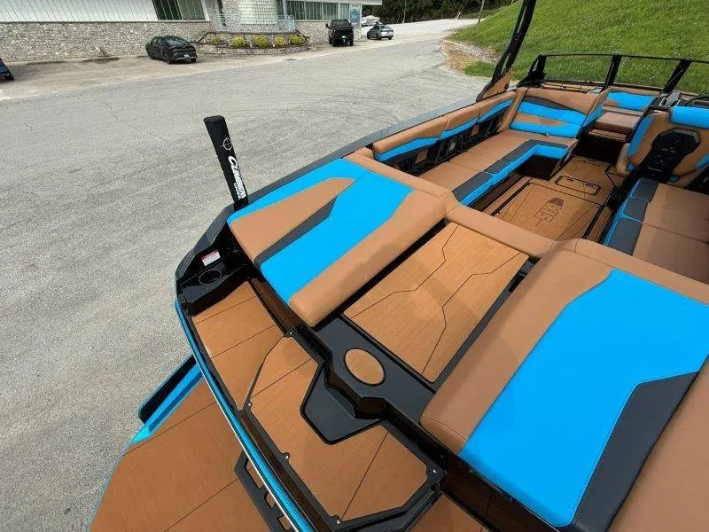 Slide: The Image of The image shows the deck of a 2027 Axis A245 boat with blue and brown upholstery. - 45