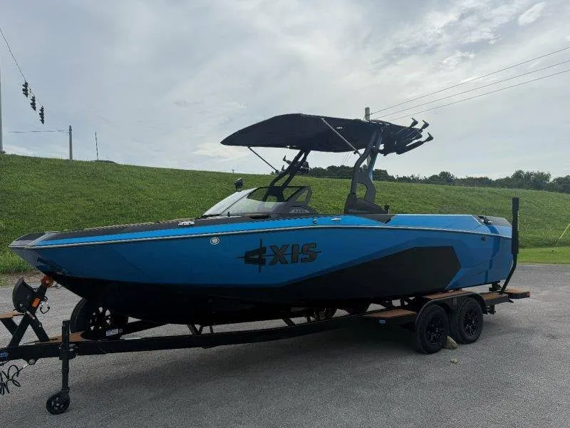 Slide: The Image of A 2027 Axis A245 boat on a trailer, blue with a black canopy. - 25