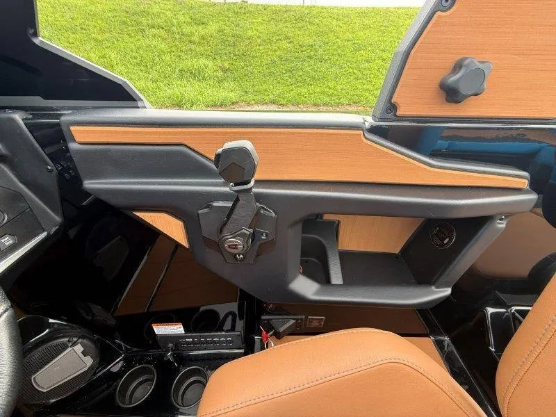Slide: The Image of The image shows the cockpit of a 2027 Axis A245 boat with modern controls and brown seats. - 28