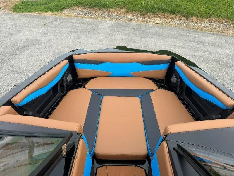 Slide: The Image of The image shows the bow of a 2027 Axis A245 boat with brown and blue upholstery. - 49