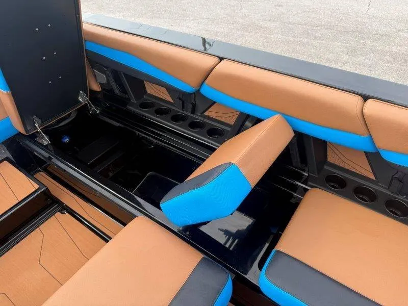 Slide: The Image of The image shows the interior of a 2027 Axis A245 boat with brown and blue seating. - 32