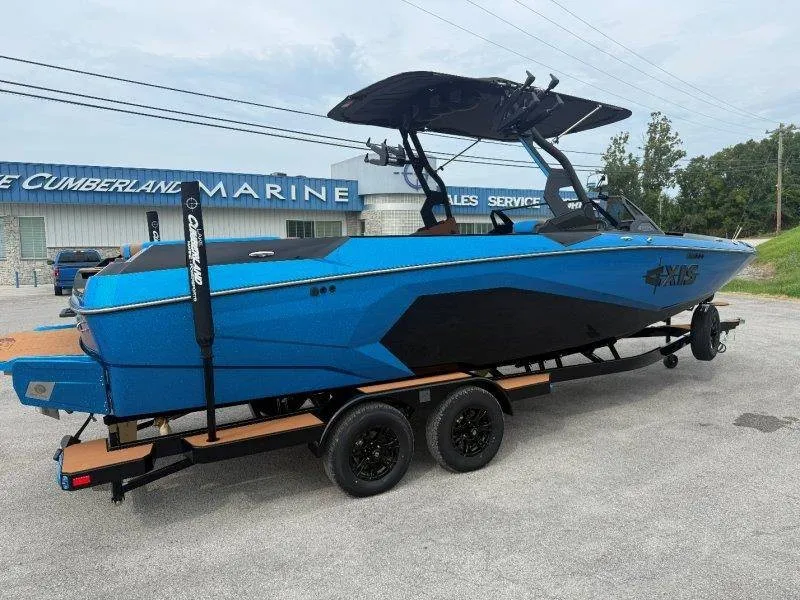 Slide: The Image of A blue Axis A245 boat on a trailer in front of a building. It features a black canopy. - 17