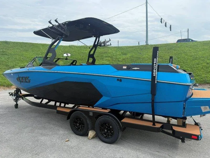 Slide: The Image of A blue Axis A245 boat from 2027 is on a trailer in a parking lot. - 21