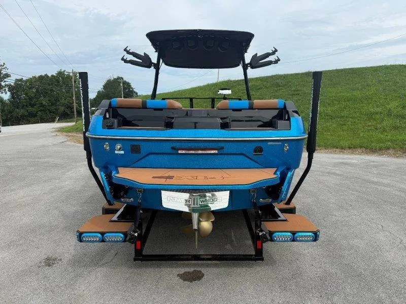 Slide: The Image of Rear view of a blue 2027 Axis A245 boat with brown seating and modern design. - 12