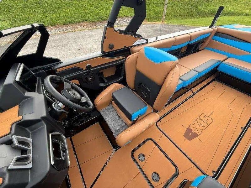 Slide: The Image of The image shows the cockpit of a 2027 Axis A245 boat with brown and blue seating. - 26