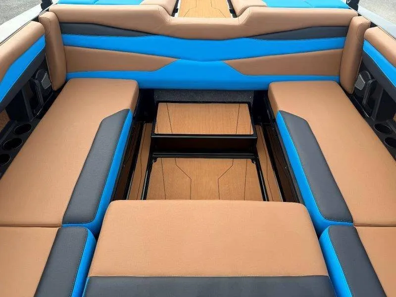 Slide: The Image of The image shows the interior of a 2027 Axis A245 boat with blue and brown seating. - 37
