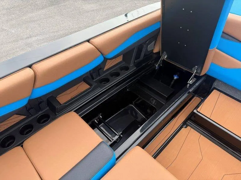 Slide: The Image of The image shows the interior of a 2027 Axis A245 boat with brown and blue seating. - 31