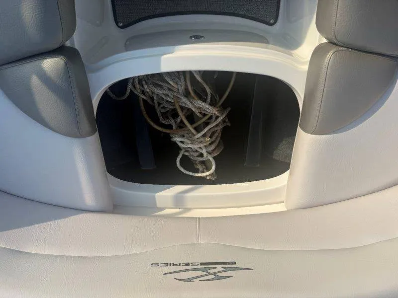 Slide: The Image of A storage compartment in the boat with ropes, surrounded by gray upholstery. - 34