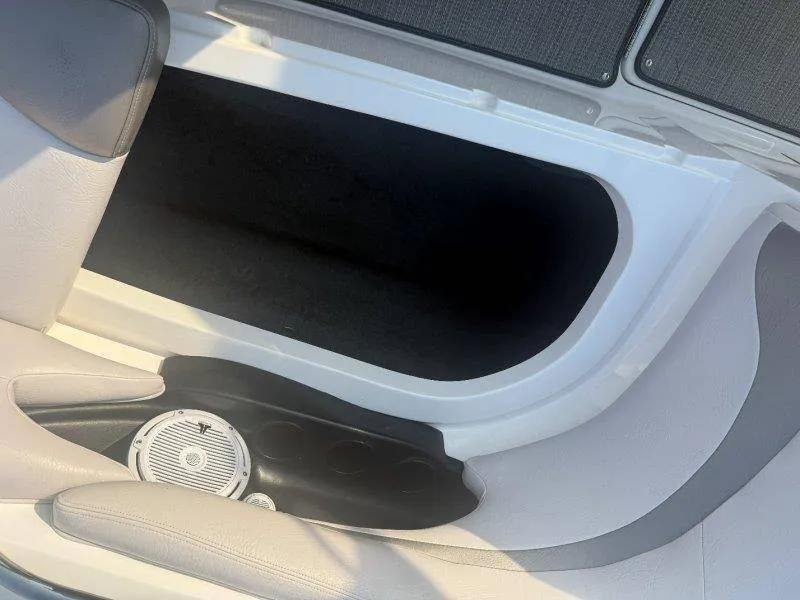 Slide: The Image of An open storage compartment in a boat with white and gray upholstery and a speaker. - 27