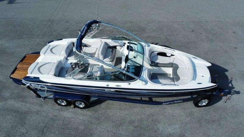 The Image of A 2006 MasterCraft X-80 with blue and white paint and dual seating rows on a trailer. - 1