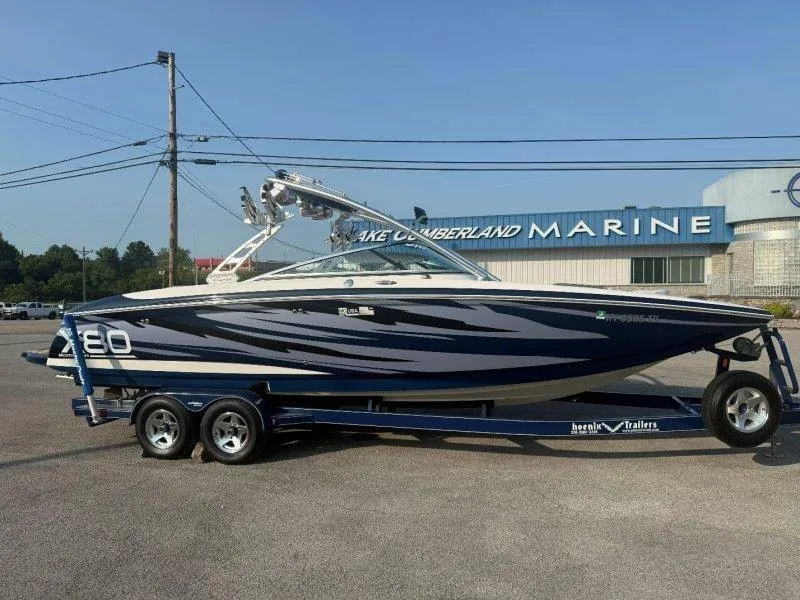 Slide: The Image of A blue and white 2006 MasterCraft X-80 boat on a trailer in front of a building. - 15