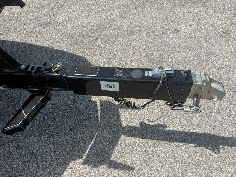 Slide: The Image of Close-up of a boat trailer with a black frame and safety cables on asphalt. - 12