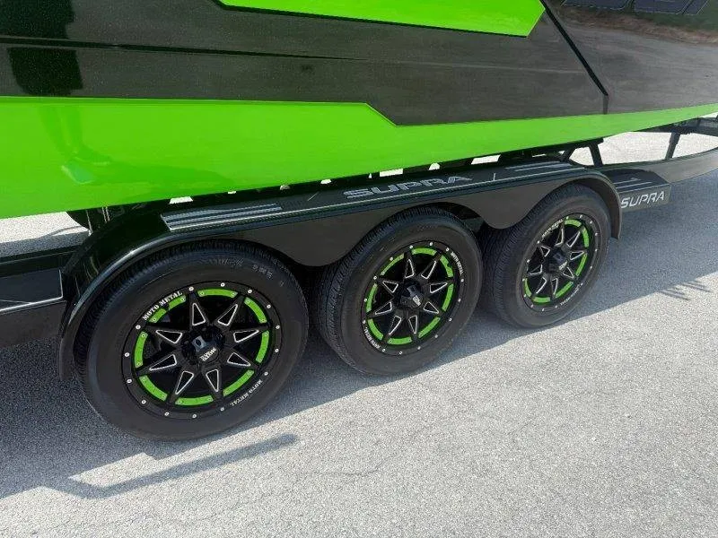 Slide: The Image of A 2023 Supra SE 550 on a trailer with green and black accents. - 17