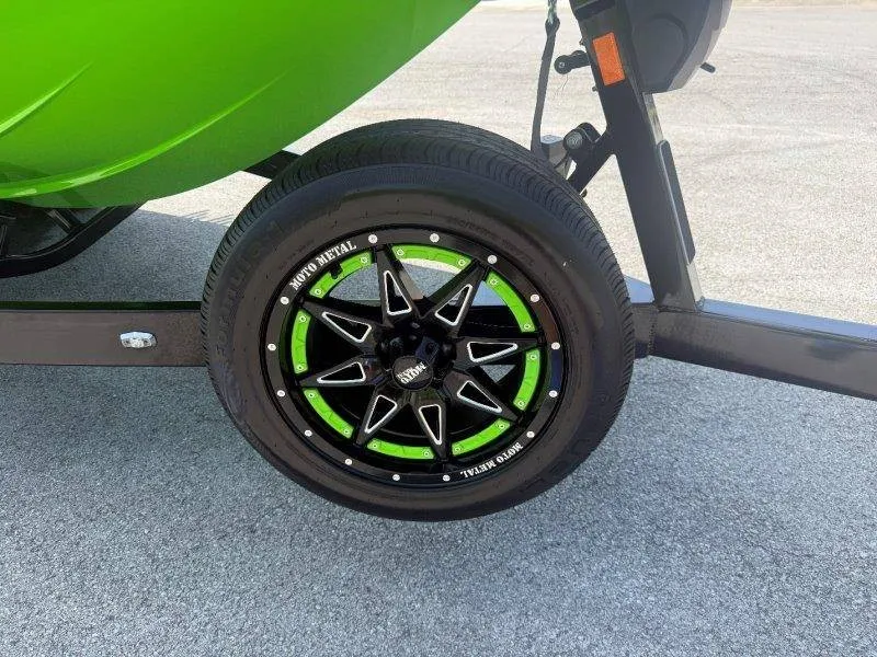 Slide: The Image of Close-up of a boat trailer wheel with green accent and black frame. - 16