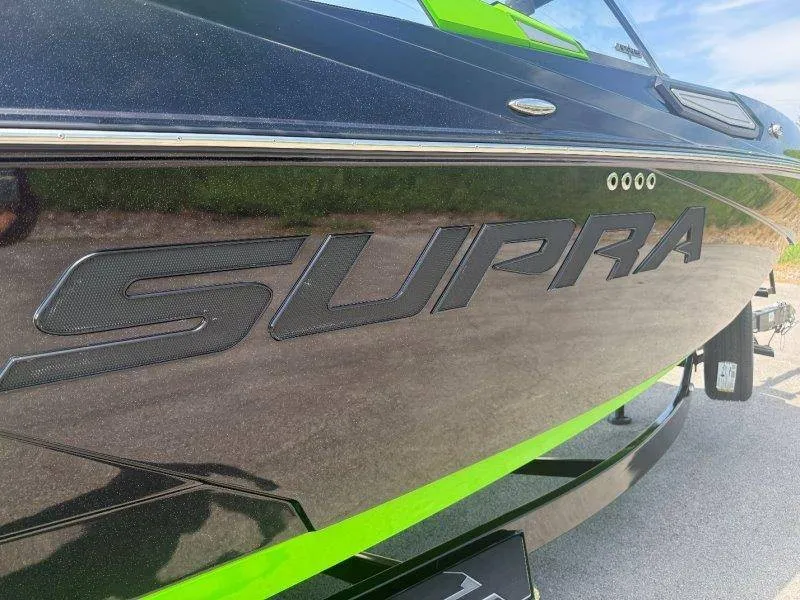 Slide: The Image of Close-up of the 2023 Supra SE 550 with a glossy black hull and green accents. - 24