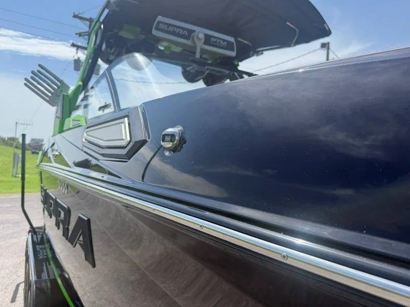 Slide: The Image of The image shows a modern boat with a sleek black hull and green accents. - 25