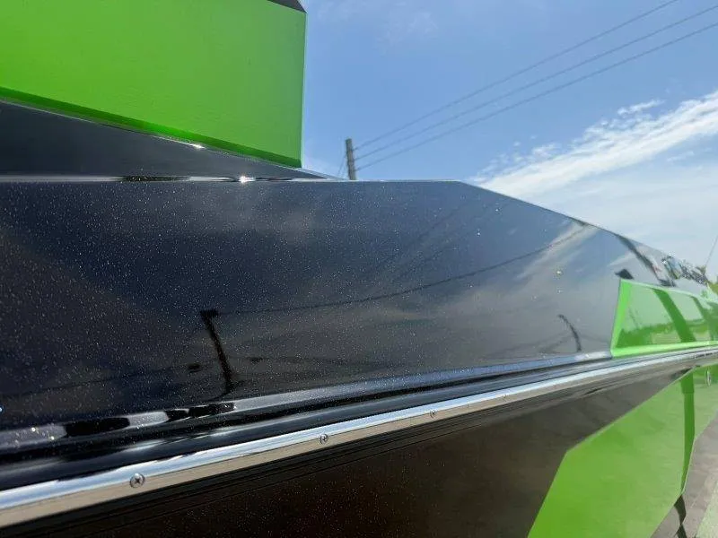 Slide: The Image of Close-up of a sleek, black and green boat hull under a blue sky. - 7