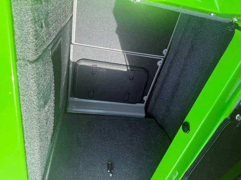 Slide: The Image of A green storage compartment inside a boat with gray carpeted flooring. - 38