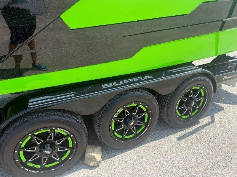 Slide: The Image of A Supra SE 550 boat on a trailer with green and black accents. - 9