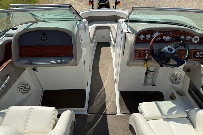 Slide: The Image of Interior of a 2003 Cobalt 246 boat featuring a sleek dashboard and steering wheel. - 7