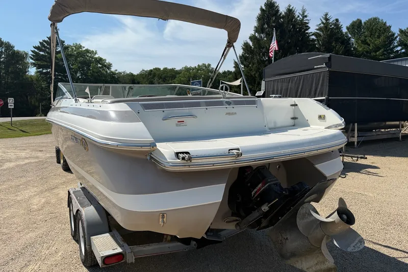 Slide: The Image of 2003 Cobalt 246 boat on trailer, rear view, parked outdoors under clear sky. - 4