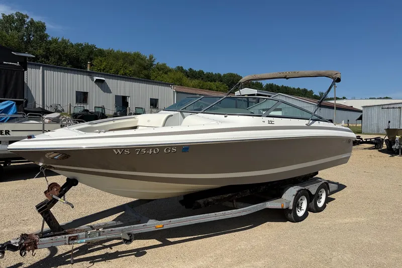 The Image of 2003 Cobalt 246 boat on trailer, parked outdoors under clear blue sky. - 1