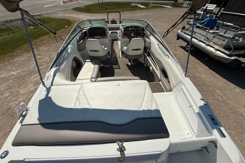 Slide: The Image of 2003 Cobalt 246 boat interior with seating and steering wheel, parked on gravel. - 14