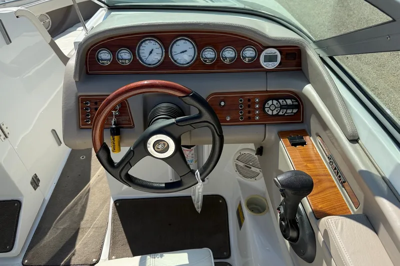 Slide: The Image of 2003 Cobalt 246 boat dashboard with wood accents and steering wheel. - 8