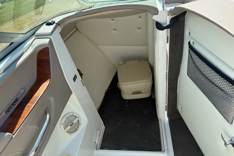 Slide: The Image of Interior of a 2003 Cobalt 246 boat featuring a compact portable toilet. - 10