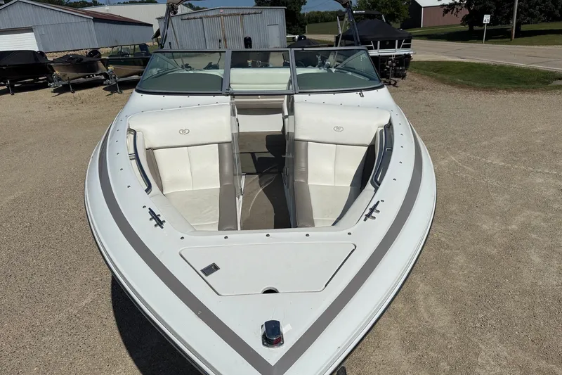 Slide: The Image of 2003 Cobalt 246 boat with white seating, parked on gravel near storage buildings. - 5
