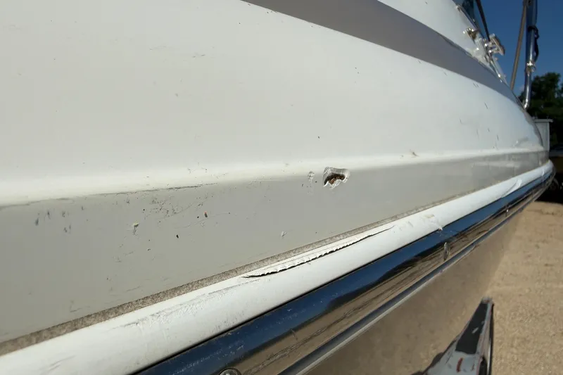 Slide: The Image of 2003 Cobalt 246 boat hull with visible damage and scratches. - 16