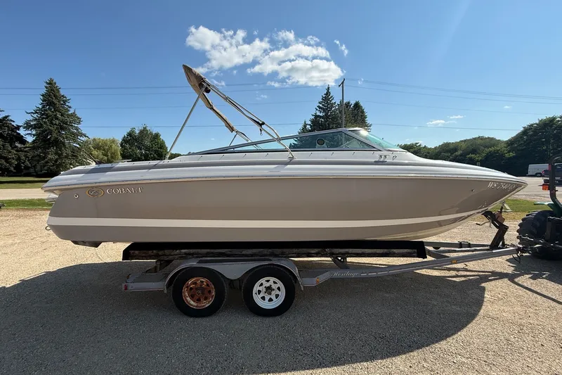 Slide: The Image of 2003 Cobalt 246 boat on trailer under clear blue sky. - 2