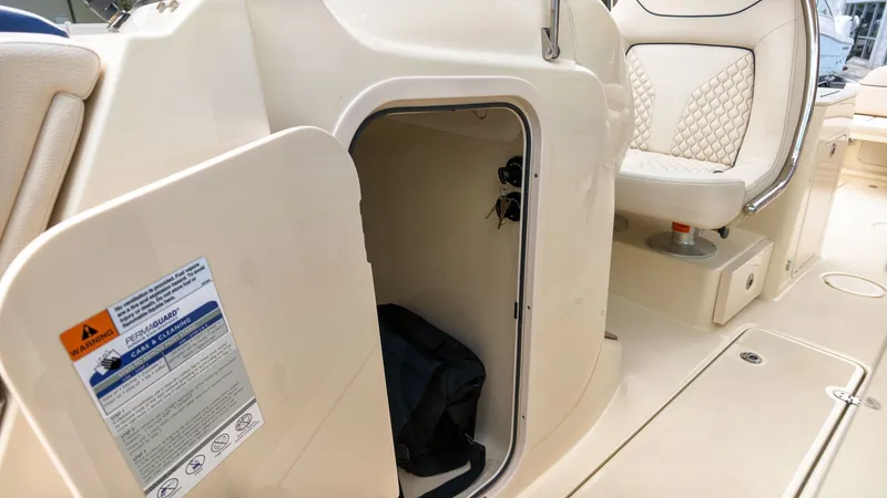 Slide: The Image of An open storage compartment on a Chris-Craft Calypso 27 boat, featuring a seat with quilted details. - 24