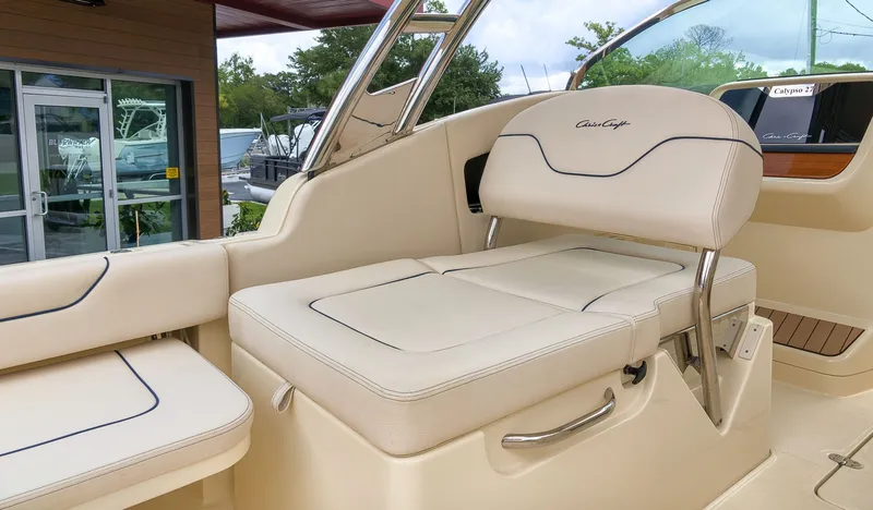 Slide: The Image of The image shows the interior of a Chris-Craft Calypso 27 boat with beige upholstery. - 14