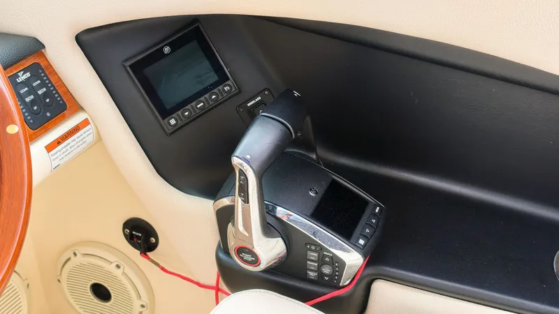 Slide: The Image of Close-up of the helm area in a Chris-Craft Calypso 27 boat with modern controls. - 27