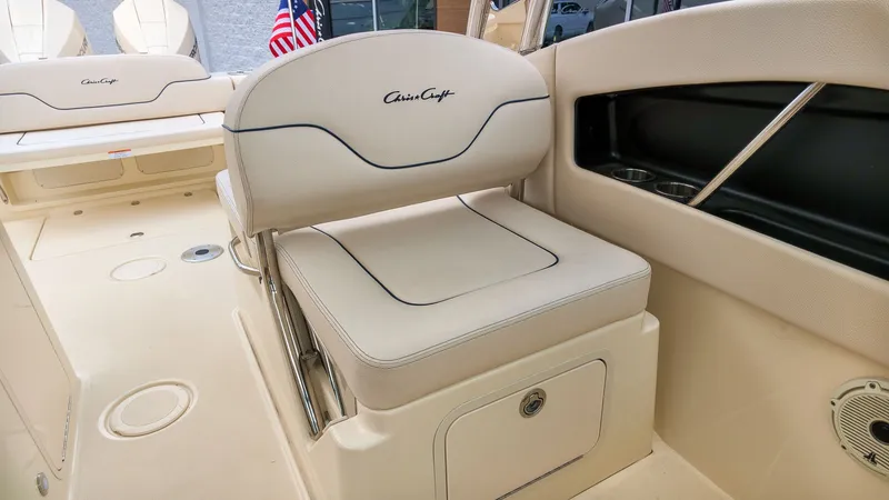 Slide: The Image of The image shows the seating area of a 2022 Chris-Craft Calypso 27 boat with beige upholstery. - 16