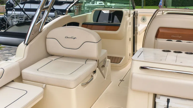 Slide: The Image of The image shows the cockpit of a 2022 Chris-Craft Calypso 27 with beige leather seating. - 28