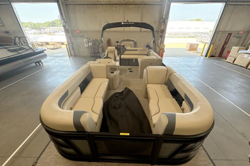 Slide: The Image of 2027 Godfrey Sweetwater 2286 SFL pontoon boat with spacious seating in a warehouse setting. - 17