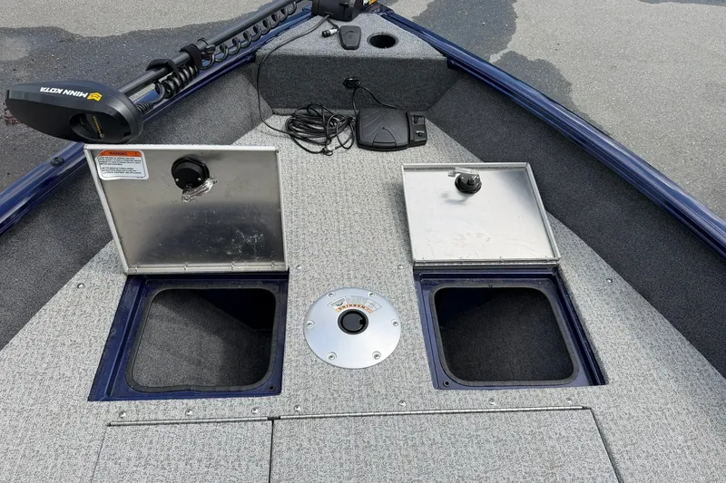 Slide: The Image of 2020 Tracker Pro Guide V-16 WT boat interior with storage compartments and trolling motor. - 13