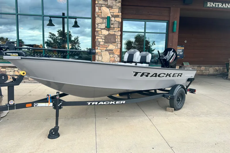 The Image of 2027 Tracker Super Guide V-16 T boat on trailer outside a building. - 0
