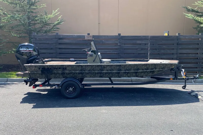 The Image of 2027 Tracker Grizzly 1860 CC boat on trailer, parked outdoors. - 0