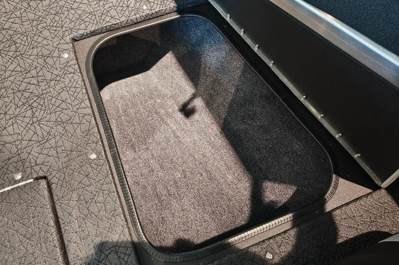 Slide: The Image of 2027 Tracker Targa V-18 WT boat storage compartment with textured flooring. - 25