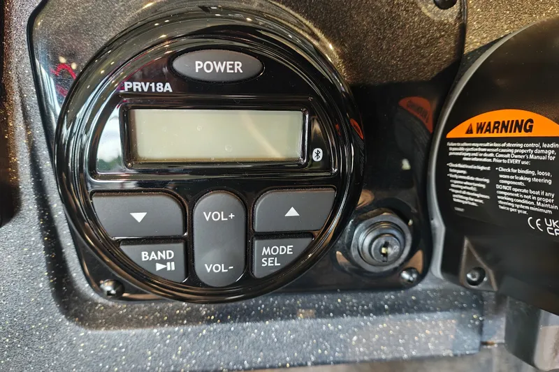 Slide: The Image of Control panel of 2027 Tracker Targa V-18 WT boat with warning label and buttons. - 14