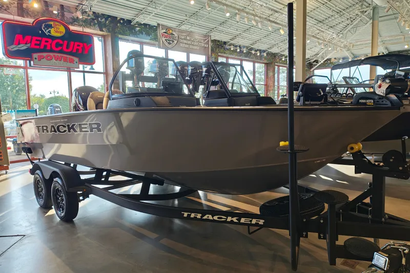 The Image of 2027 Tracker Targa V-18 WT boat displayed indoors with Mercury Power signage. - 1