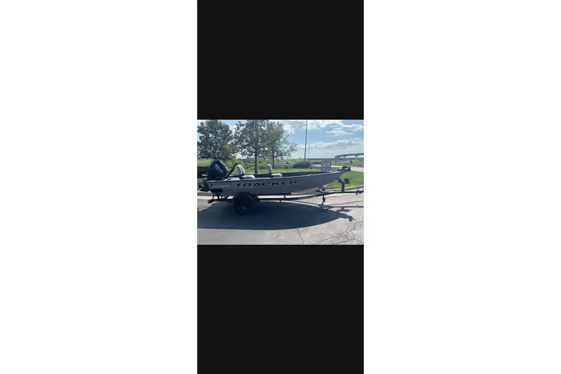 The Image of 2027 Tracker Super Guide V-16 T boat on trailer, parked outdoors. - 0