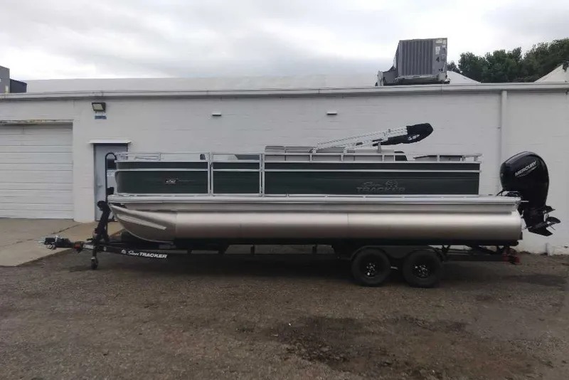 The Image of 2027 Sun Tracker Party Barge 22 DLX pontoon boat on trailer, parked outdoors. - 0